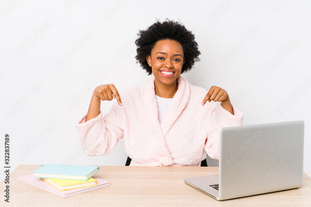Middle aged african american woman working at home isolated points down with fingers, positive feeling. Middle aged african american woman working at home isolated points down with fingers, positive feeling.