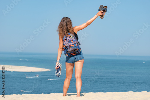 Portrait belle et charmante jeune femme caucasian brune aux yeux bleu joyeuse et confiance en soi séduisante chanceuse charismatique française européenne heureuse zen à liberté plage dune du pilat