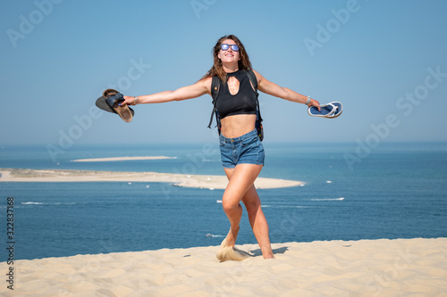 Portrait belle et charmante jeune femme caucasian brune aux yeux bleu joyeuse et confiance en soi séduisante chanceuse charismatique française européenne heureuse zen à plage océan dune du pilat