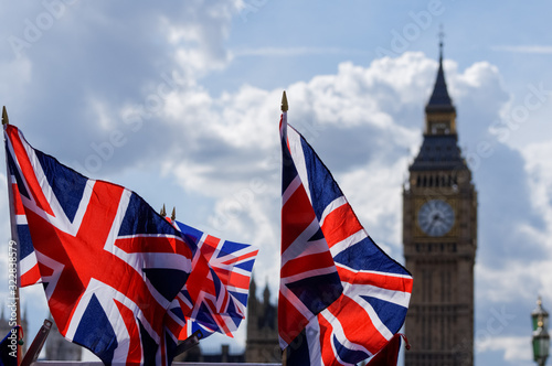 Big Ben at the Palace of Westminster with Union Jack flags in the foreground