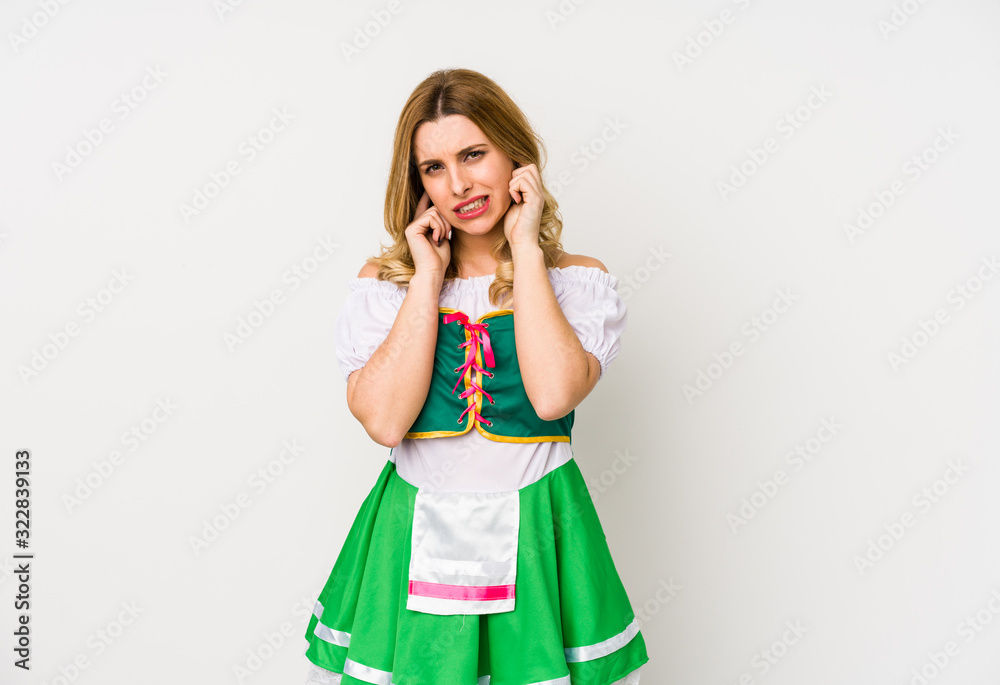 Young woman wearing a saint patricks day clothes isolated covering ears with hands.