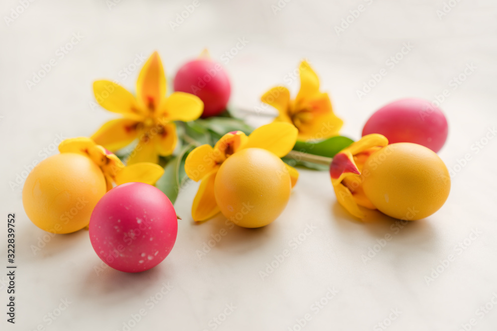 Easter eggs with yellow tulips on a light background Easter eggs with yellow tulips on a light background