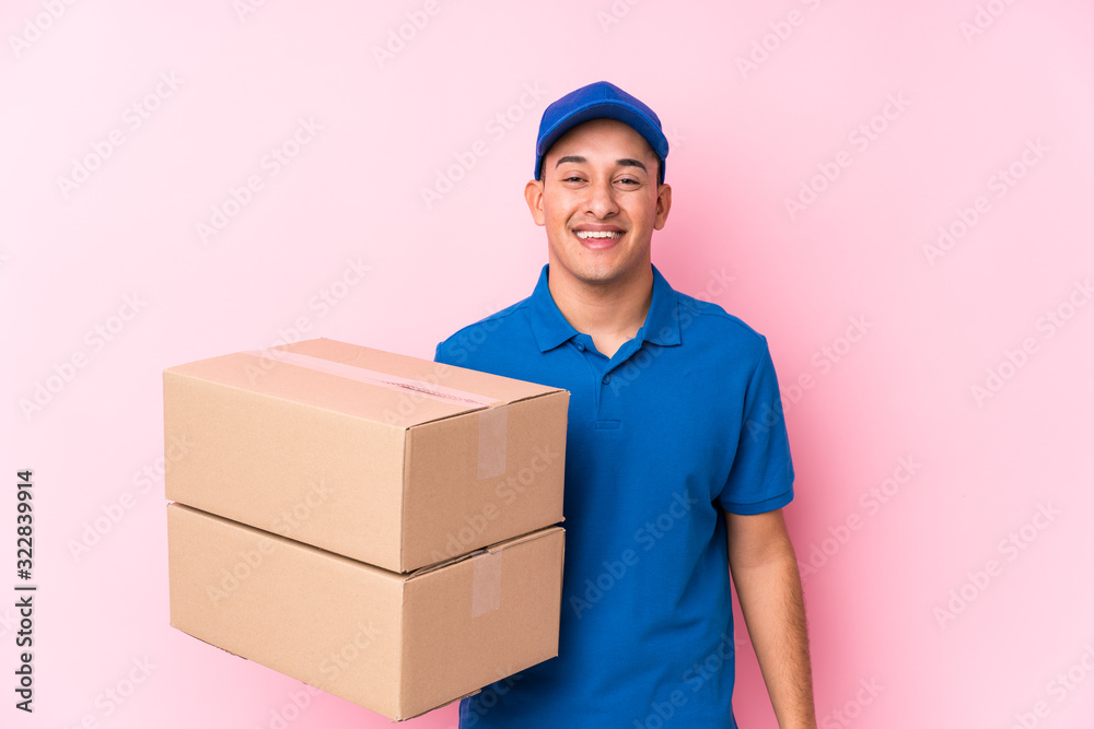 Young latin delivery man isolated laughing and having fun. Young latin delivery man isolated laughing and having fun.