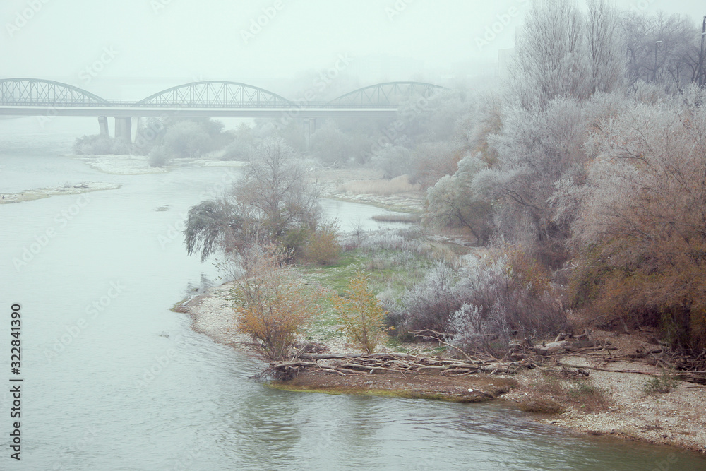 Fototapeta premium river with mist and bridge town in the background