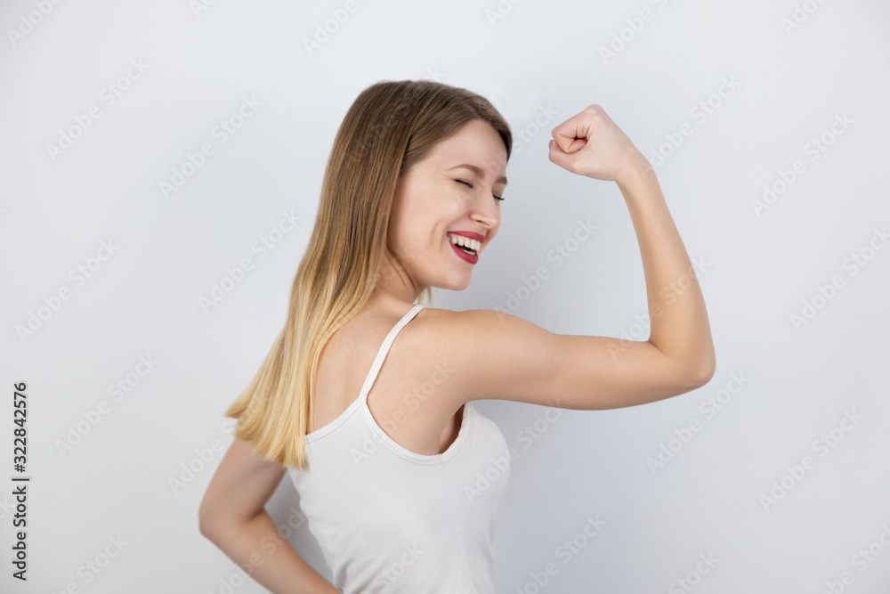 portrait of beautiful fit blond woman demonstrates her arm biceps looking strong standing on isolated white background, healthcare and sport concept portrait of beautiful fit blond woman demonstrates her arm biceps looking strong standing on isolated white background, healthcare and sport concept