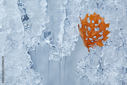 Close-up of a leaf and winter cascade framed by ice, Comstock Creek Cascade, Michigan, USA photo