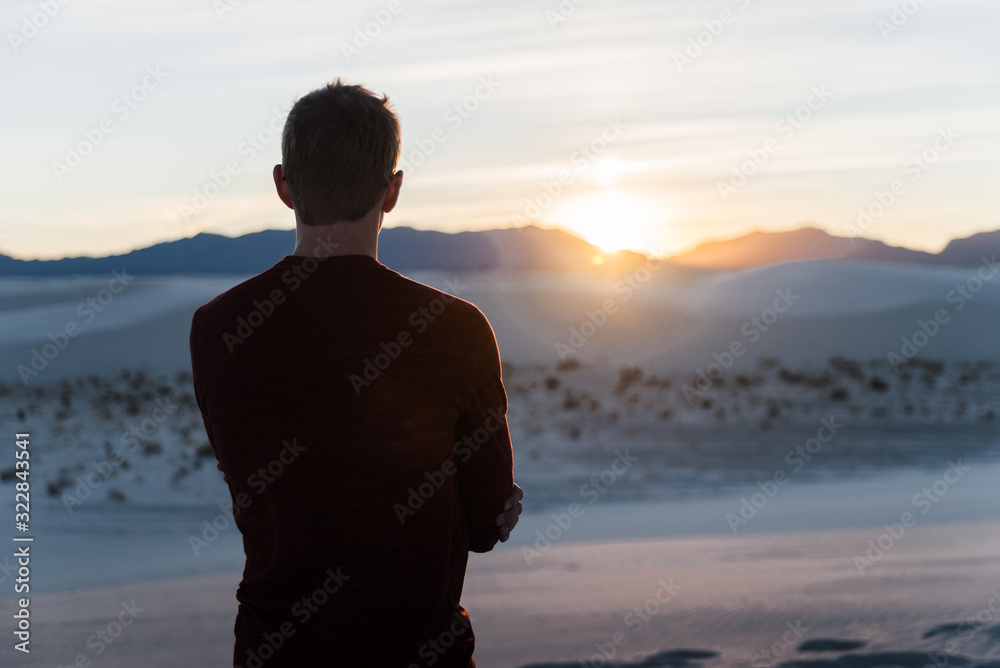 A man looking into the sunset at White Sands National Park in New Mexico. A man looking into the sunset at White Sands National Park in New Mexico.