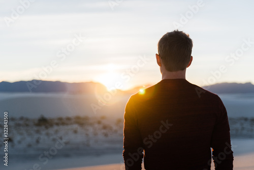 Fototapeta Naklejka Na Ścianę i Meble -  A man looking into the sunset at White Sands National Park in New Mexico. 
