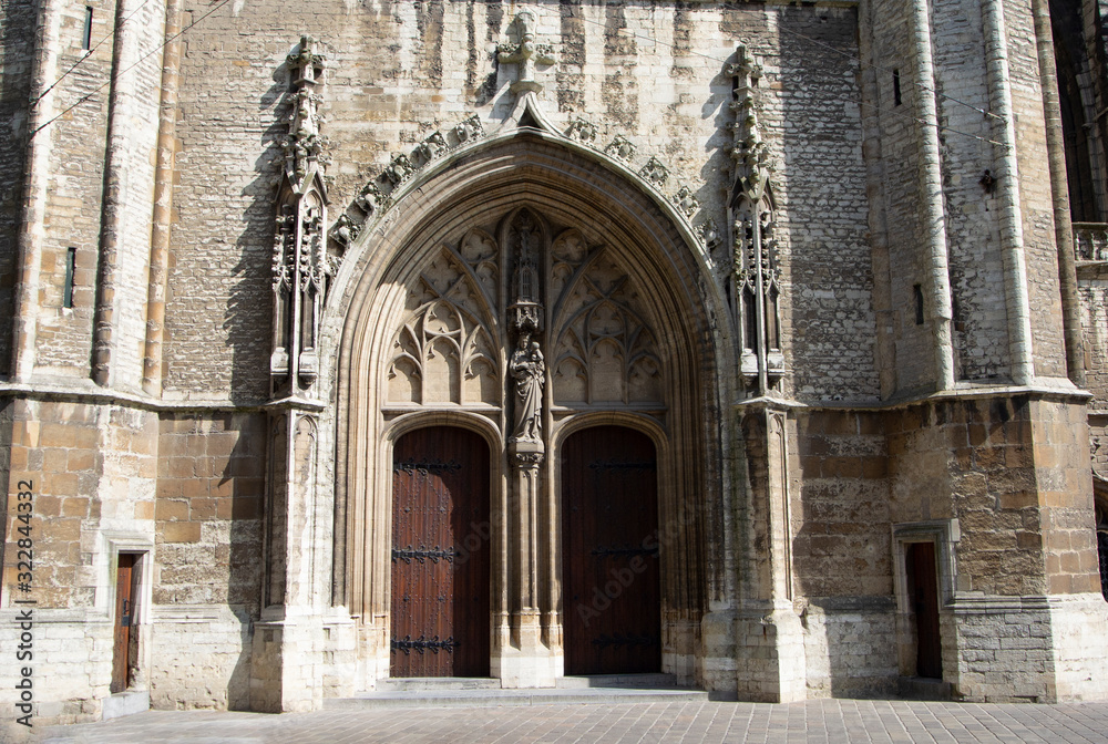 Entrance to the Saint Bavo cathedral in the historic Belgium city of Ghent.  Ornate stone carvings decorate the building.