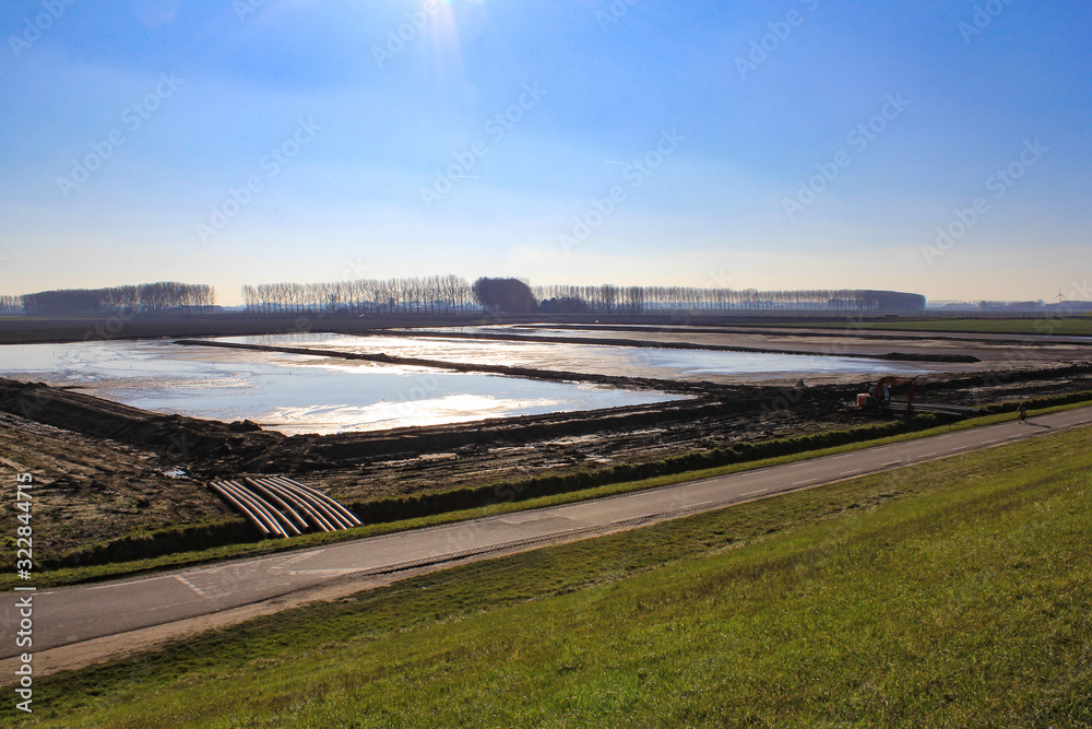 big water reservoirs in the dutch countryside in winter with a blue sky