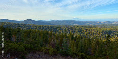Evening panoramic view over the wooded mountains in Oregon. Mountains Adams and Rainier in the background.