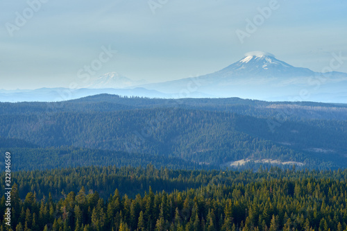 Mountains Adams and Rainier evening view over the wooded mountains in Oregon.