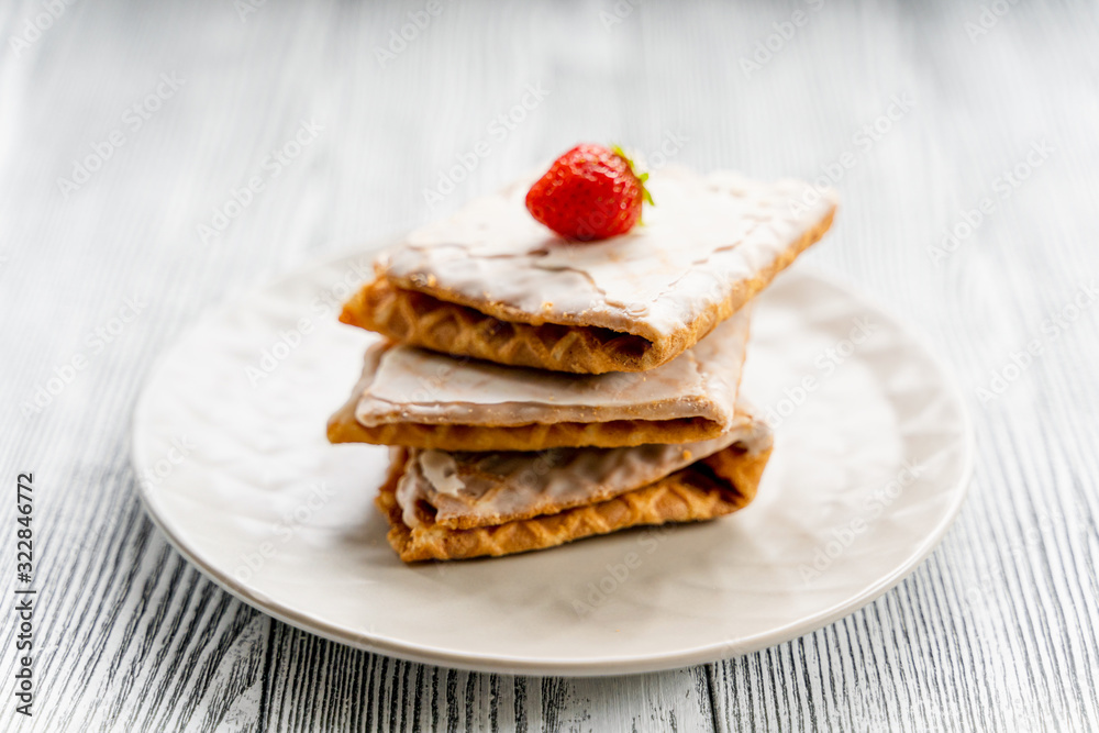 Waffles and strawberries on a grey wooden background. Dessert with berries. Waffles and strawberries on a grey wooden background. Dessert with berries.