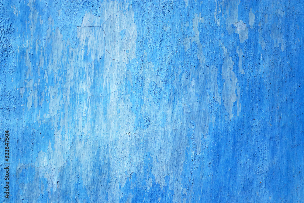 Blue wall texture background. Old wall fragment with external peeled and cracked plaster