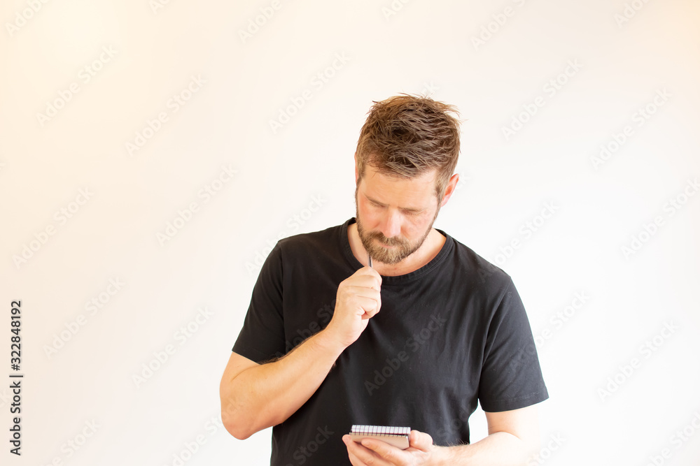 Young man in black writing in a notebook Young man in black writing in a notebook