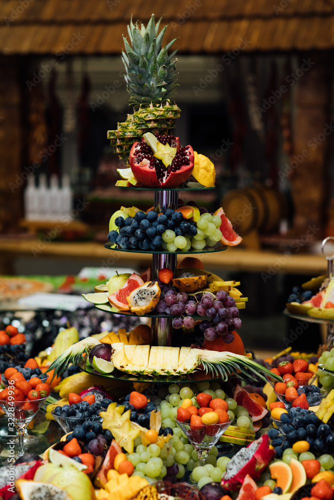 Carved fruits arrangement. Fresh various fruits. Assortment of exotic fruits. Fresh fruits decoration. Catering table with different kind of fruits. Various sweet sliced fruit on a buffet table.
