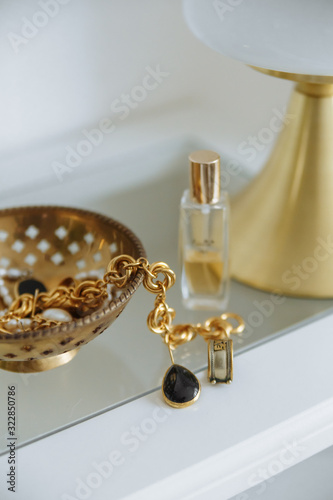 Gold lapm gold accessories jewelry white table in cozy interior photo