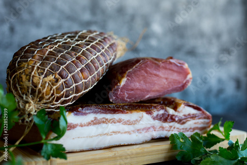 Ham and bacon on dark background.