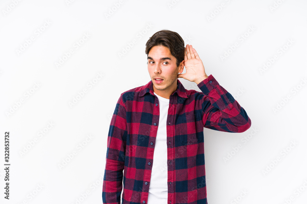 Young caucasian man posing in a pink background isolated trying to listening a gossip. Young caucasian man posing in a pink background isolated trying to listening a gossip.