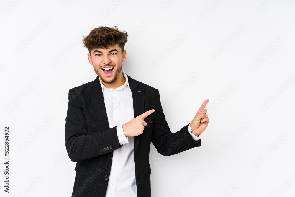Young arabian business man isolated pointing with forefingers to a copy space, expressing excitement and desire. Young arabian business man isolated pointing with forefingers to a copy space, expressing excitement and desire.