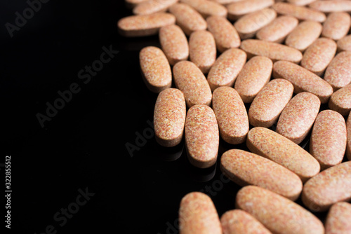 Large pills close-up on a black background on the right side of the frame.
