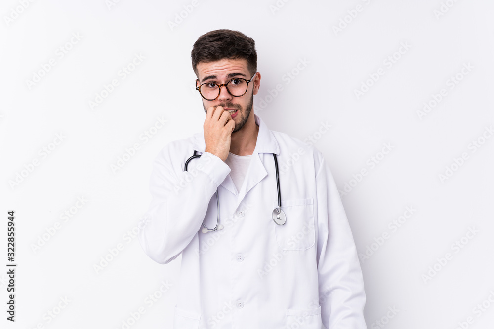 Young caucasian doctor man isolated biting fingernails, nervous and very anxious. Young caucasian doctor man isolated biting fingernails, nervous and very anxious.