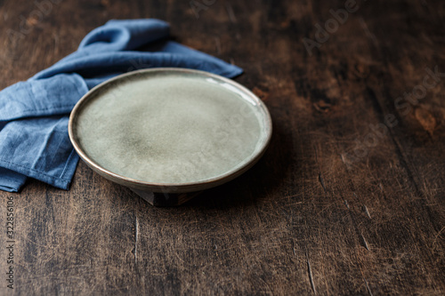 Empty plate and blue towel over wooden table photo