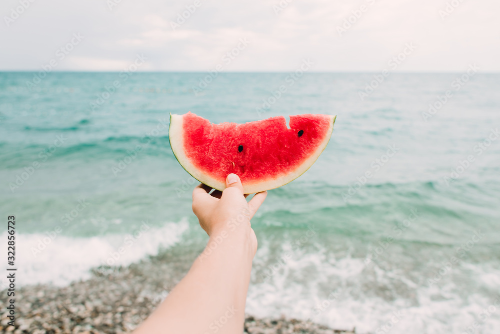 a slice of ripe juicy watermelon in the hands of the sea a slice of ripe juicy watermelon in the hands of the sea