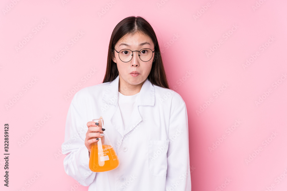 Young chinese scientific woman isolated shrugs shoulders and open eyes confused. Young chinese scientific woman isolated shrugs shoulders and open eyes confused.