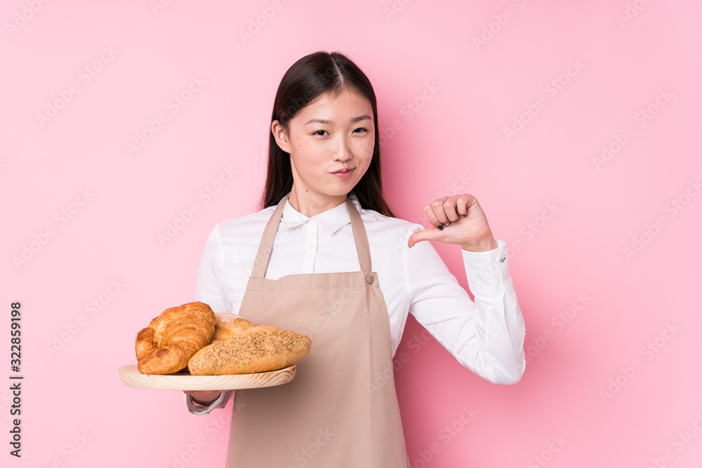 Young chinese baker woman isolated feels proud and self confident, example to follow. Young chinese baker woman isolated feels proud and self confident, example to follow.