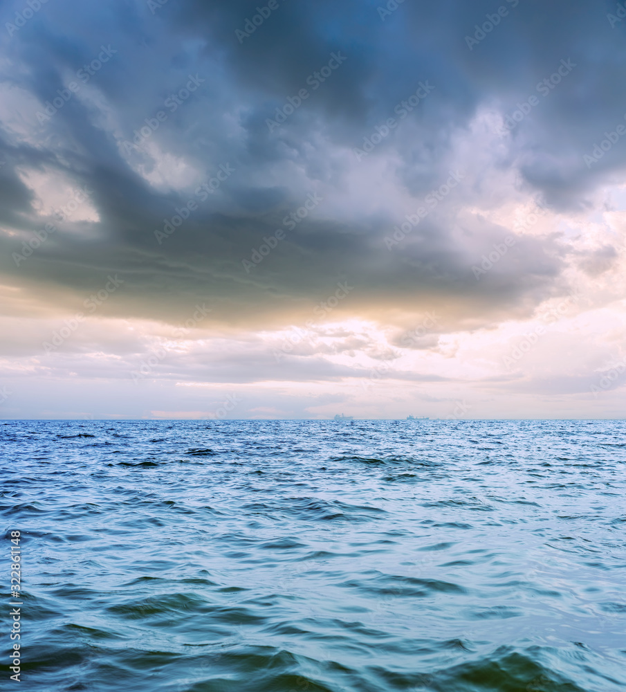 Obraz premium low dramatic clouds over dark sea in sunset