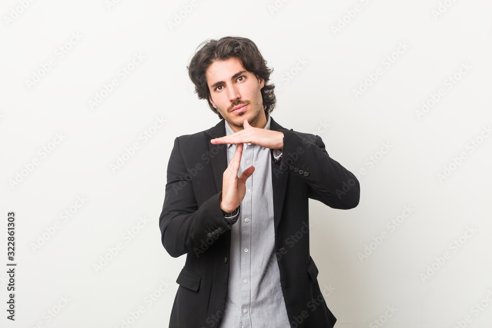 Young business man against a white background showing a timeout gesture. Young business man against a white background showing a timeout gesture.