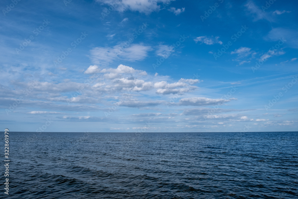 baltic sea with small waves and blue sky with white clouds.