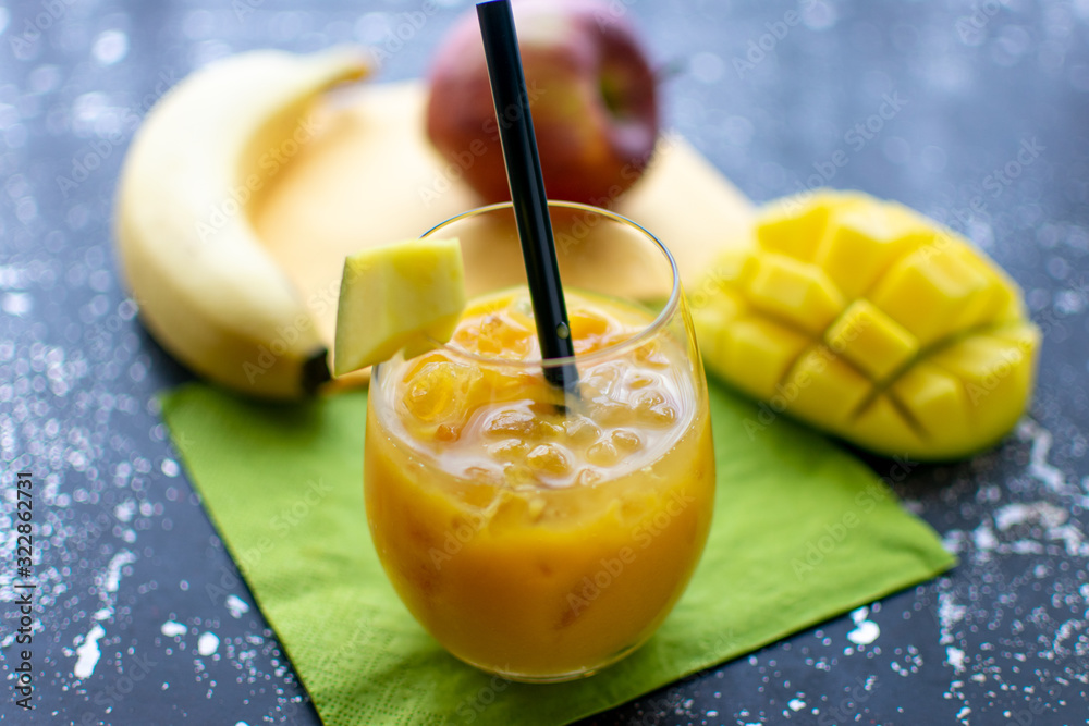 leckerer Mango Smoothie mit crushed ice und Strohhalm im Trinkglas. Im ...