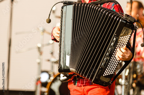 Male playing on the accordion against a grunge background