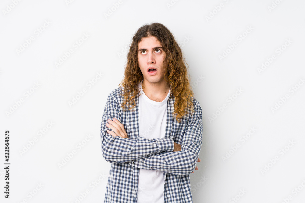 Young long hair man posing isolated tired of a repetitive task. Young long hair man posing isolated tired of a repetitive task.