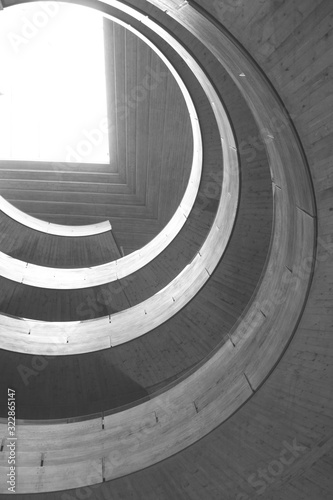 Architectural structure in grey concrete. Multi-level structure with a circular design illuminated by light from above.
