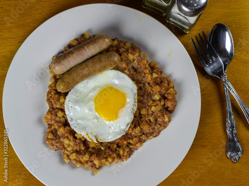 corn beef hash with fried egg and sausage photo