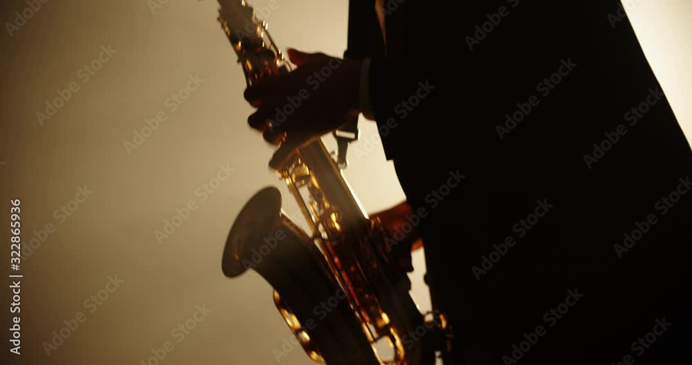 Cool saxophonist wearing a suit and performing an amazing solo. Musician doing a concert with jazz band - music, arts concept 4k footage