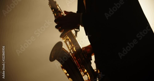 Cool saxophonist wearing a suit and performing an amazing solo. Musician doing a concert with jazz band - music, arts concept 4k footage photo