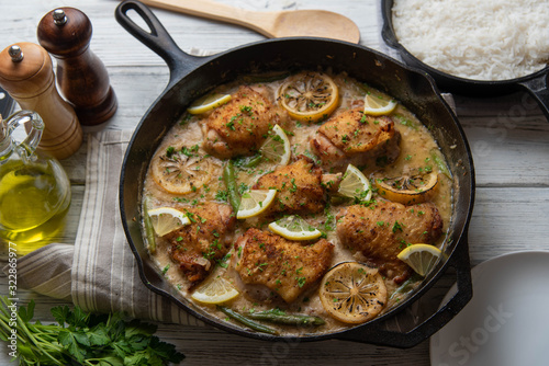 lemon butter chicken in iron skillet with cooked rice
