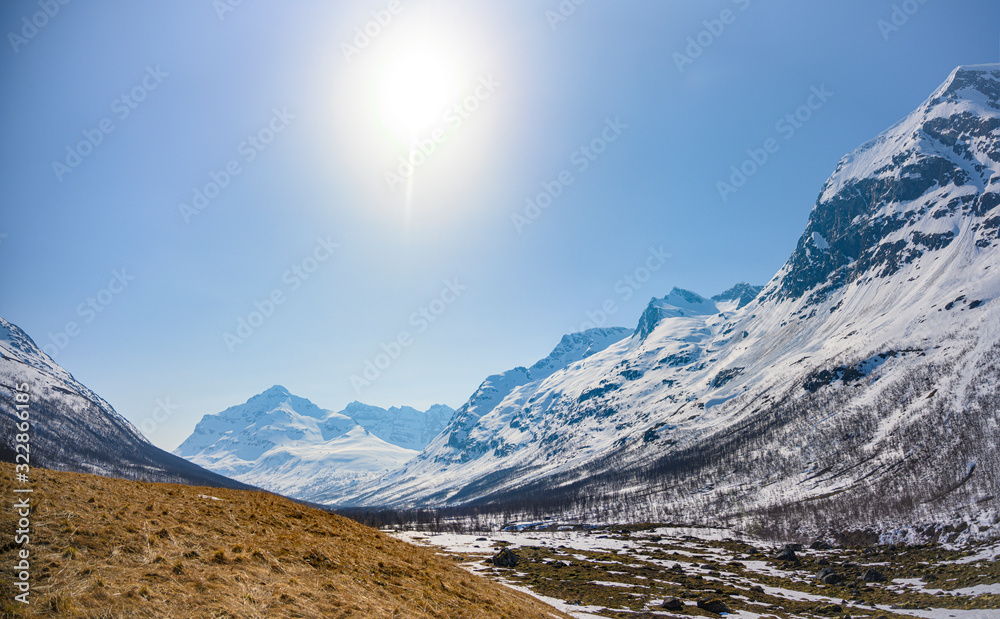 Beautiful view of the snowy mountains with the sun. North of Norway.