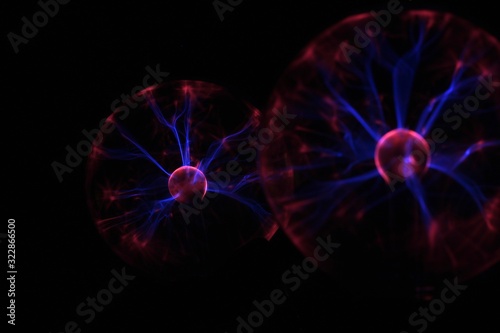 Photograph. Stylized photo of a coronavirus. Blurred image with multi-colored rays on a black background.