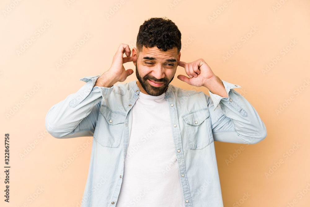 Young mixed race arabic man isolated covering ears with hands. Young mixed race arabic man isolated covering ears with hands.