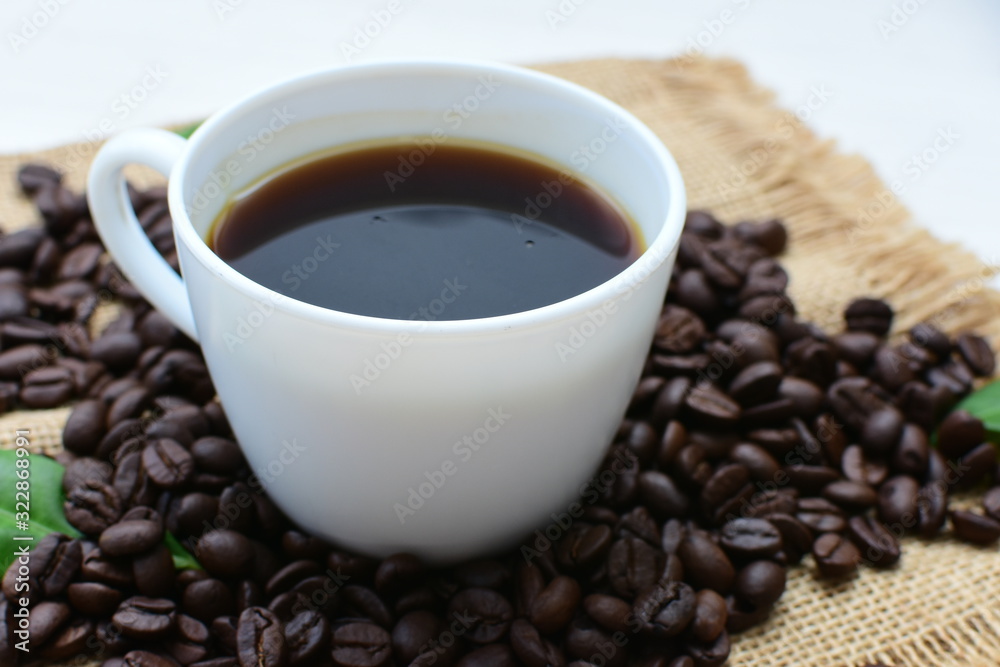 Coffee beans, accompanied by cup of hot coffee Coffee beans, accompanied by cup of hot coffee