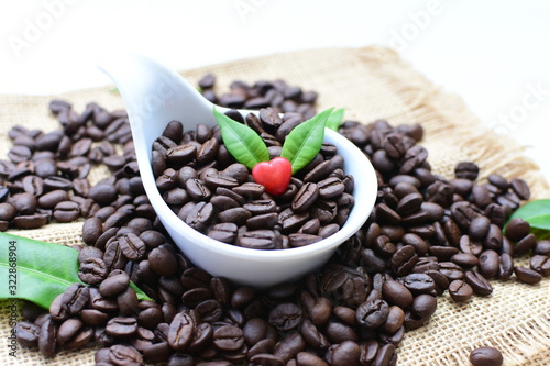 Coffee beans decorated with red heart and green leaves