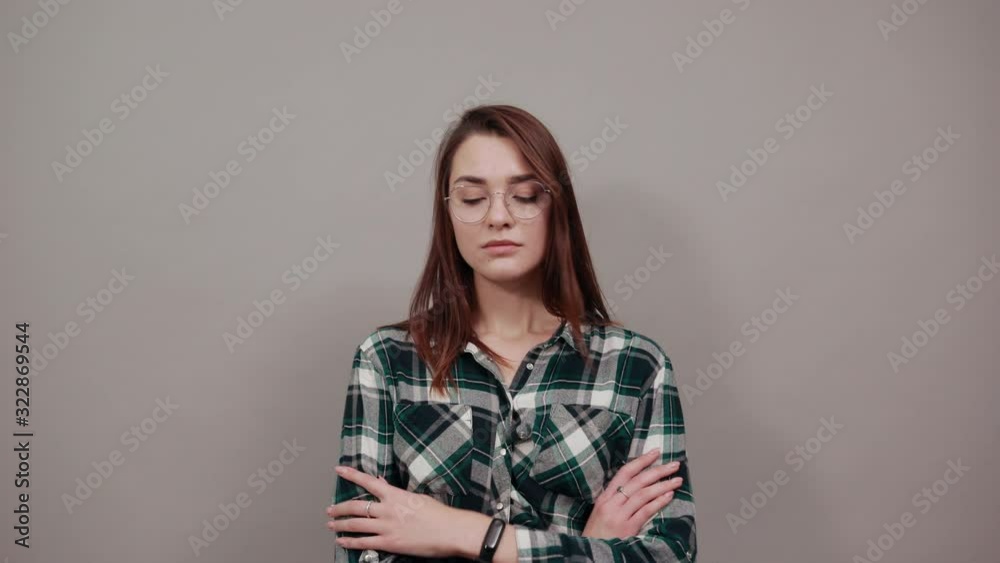 Young brunette girl blue green in checked shirt on grey background upset woman shows bad mood Young brunette girl blue green in checked shirt on grey background upset woman shows bad mood