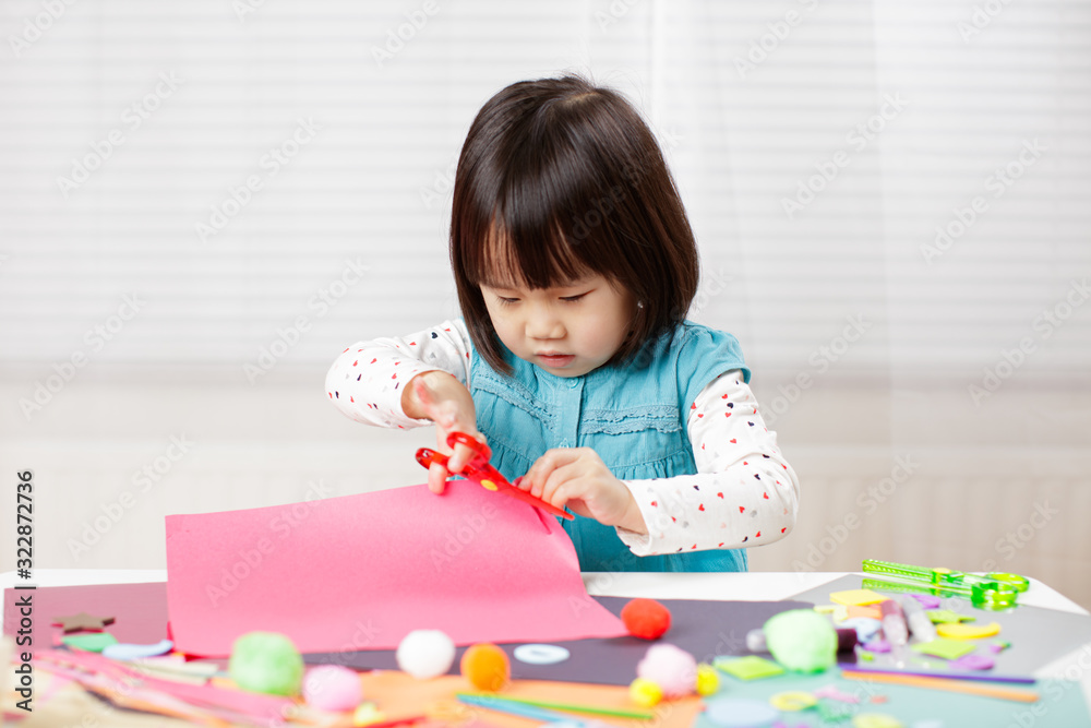 toddler girl learn making Origami at home against white background toddler girl learn making Origami at home against white background
