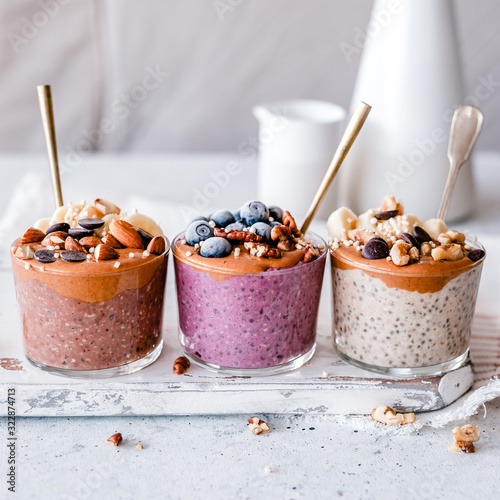 Chocolate, blueberry and vanilla oatmeal cups with peanut butter, fruit and nuts photo