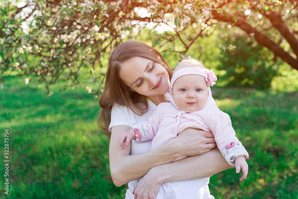 Young beautiful woman holds on hands of the little daughter. Parenthood motherhood concept Young beautiful woman holds on hands of the little daughter. Parenthood motherhood concept
